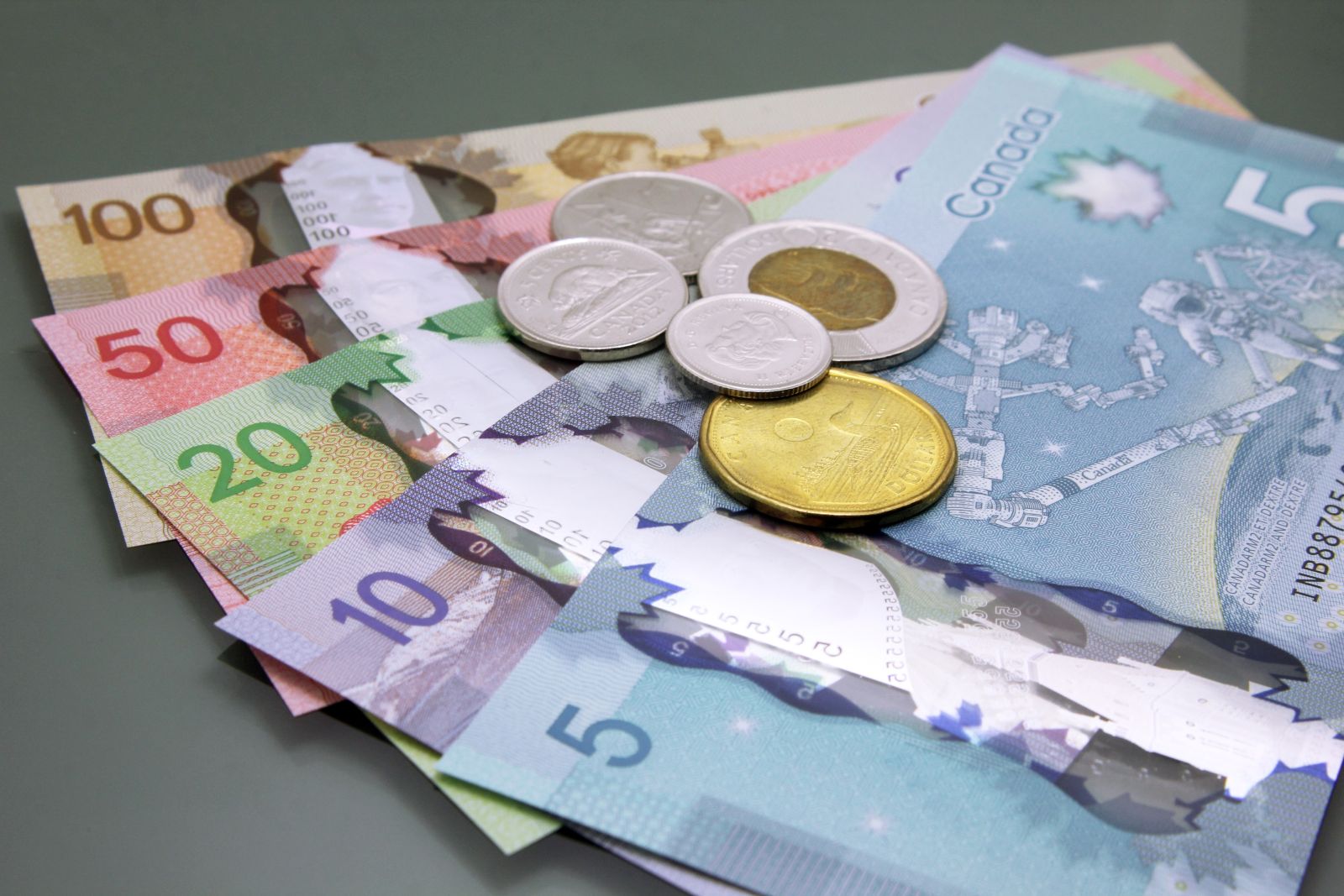 A pile of Canadian banknotes and coins_ Image by Kikinuchi via Shutterstock_