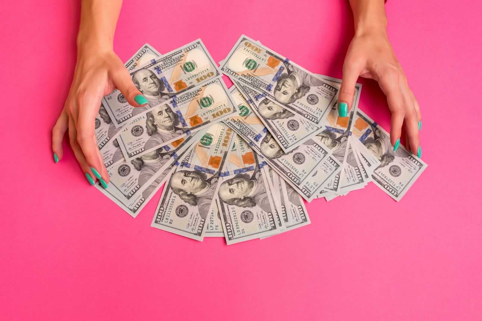Pile of money with hands by Sergey Nazarov via iStock