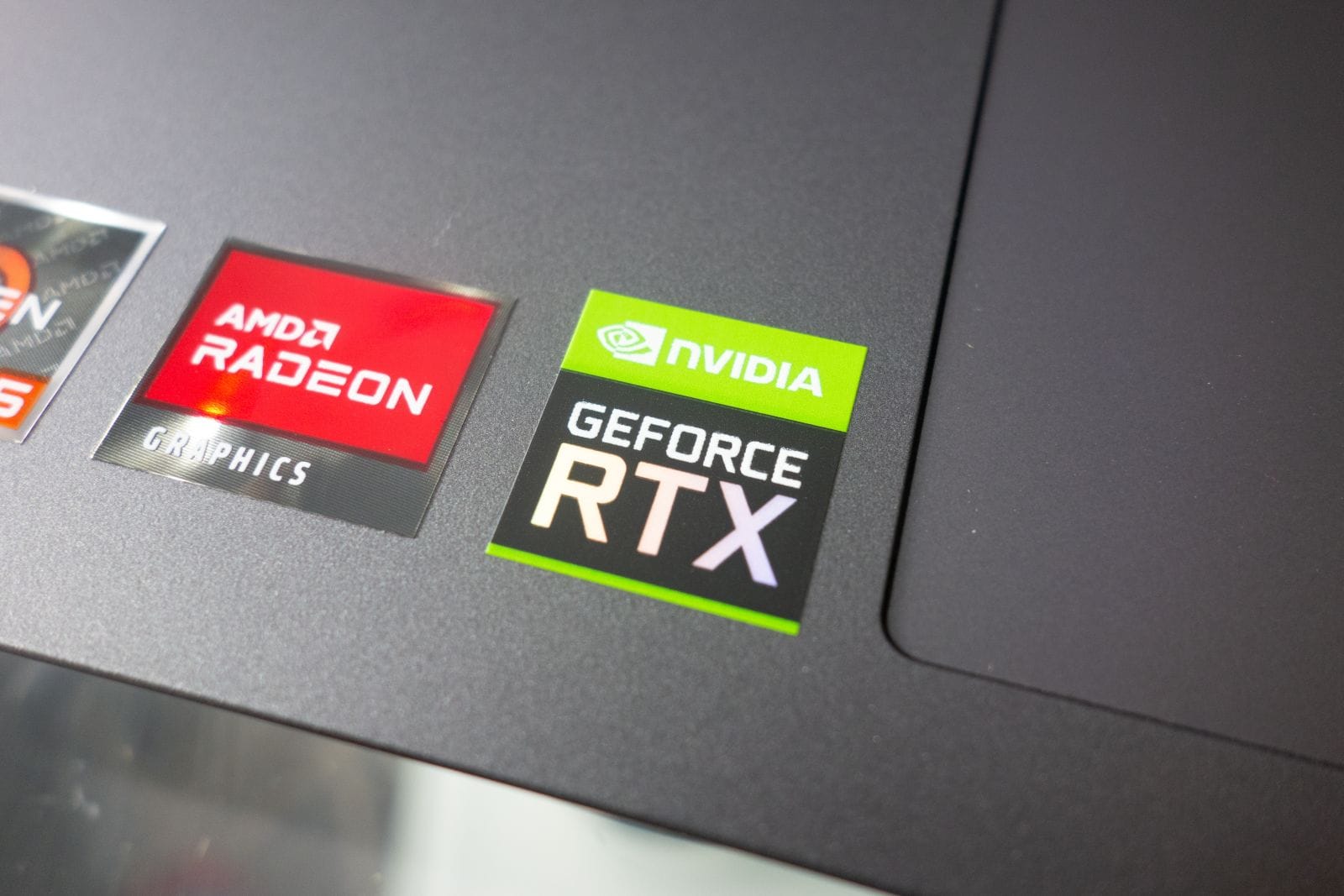 Stickers with AMD Radeon and Nvidia GeForce RTX graphics on new laptop computer by Piotr Swat via Shutterstock